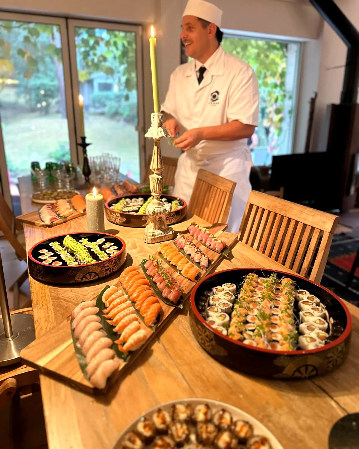Table de réception couverte de plateaux de sushis, chandelier et bougies